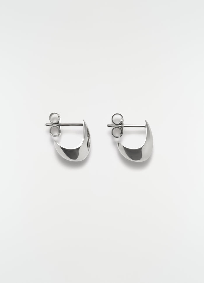 Micro drop silver metal earrings by LEMAIRE flat lay on white background showing front detail