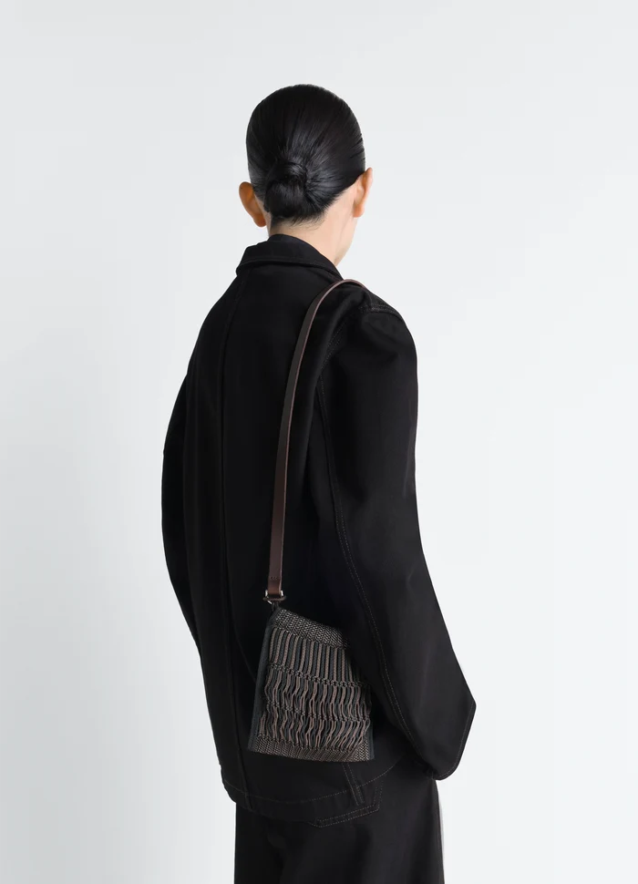Lemaire Mini Crossbody Filt Net Bag in Nylon Mesh with Leather Strap, model shot, back view textured leather strap