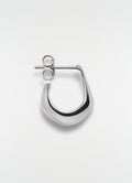 Mini silver metal drop earring by LEMAIRE on plain white background close-up detail