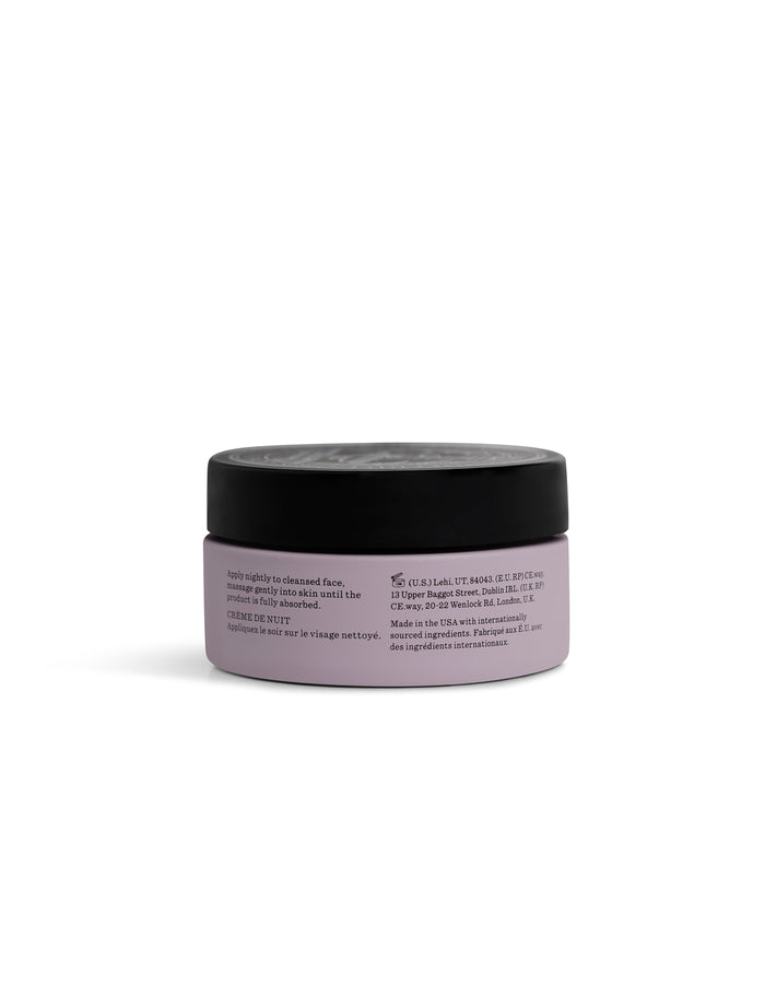 A small, round, lavender-colored jar of Cozy Earth Day-to-Night Essentials with a black lid is shown from the back, displaying label text instructions and product details against a plain white background.|Size:Full Size