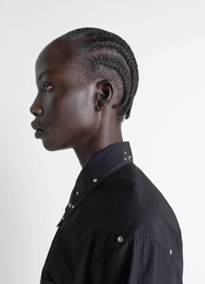 Piercings Set in Silver in Rhodium-Plated Silver, model shot, close-up left profile braided hairstyle, studded shirt
