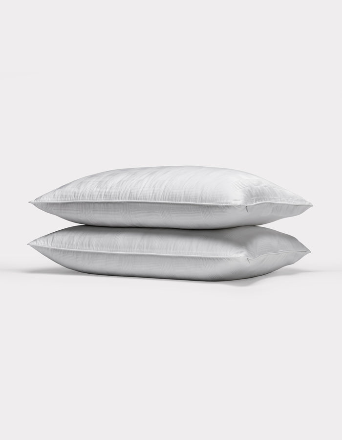 Two Cozy Earth Pillow Protectors are stacked together against a plain, light gray background.