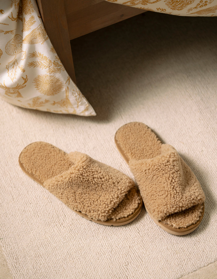 Pair of beige Cozy Earth Puffy Sheep Slides on a carpeted floor |Color:Fawn