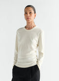 Rib long sleeve cream jersey top by LEMAIRE worn by model front view with hands in pockets