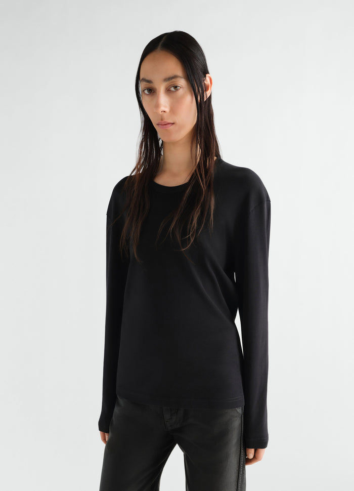 Rib long sleeve black jersey top by LEMAIRE worn by model front view with leather pants