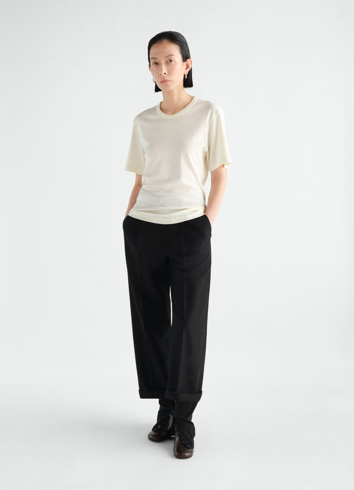 Rib cream jersey T-shirt LEMAIRE worn by model styled with black pants and buttoned boots front view