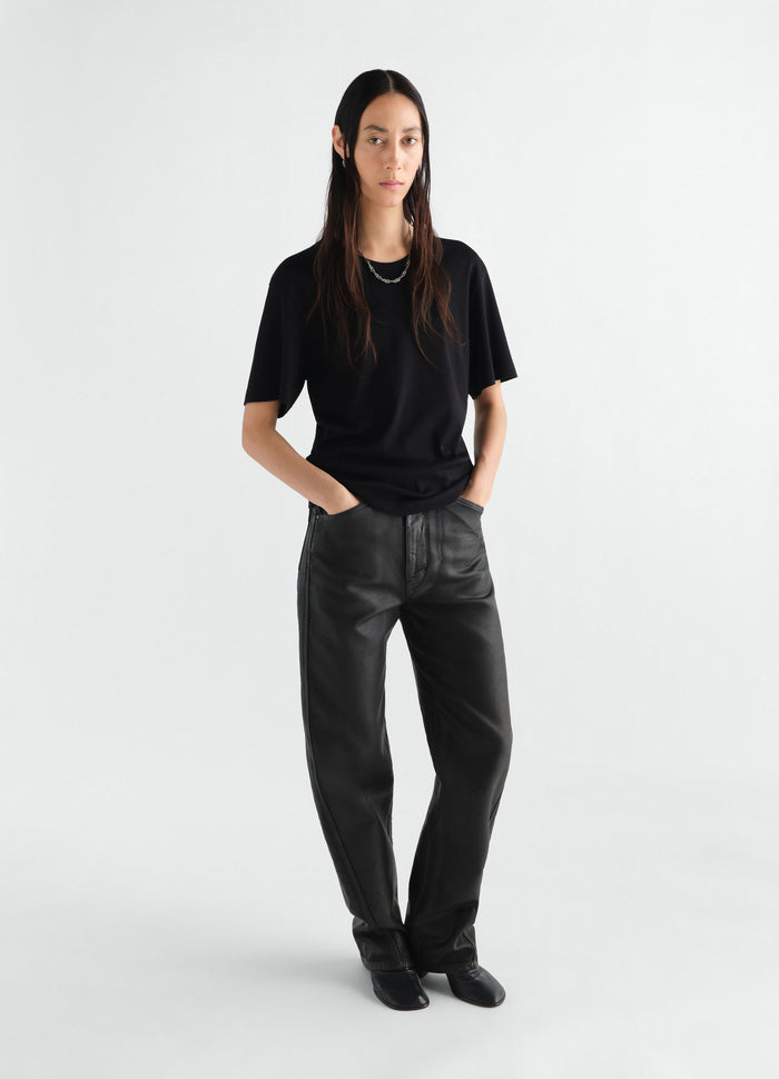 Rib black jersey T-shirt by LEMAIRE worn by model with black leather pants on white background