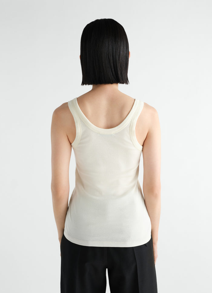 Rib tank top in off-white jersey by LEMAIRE worn by model back view on plain background