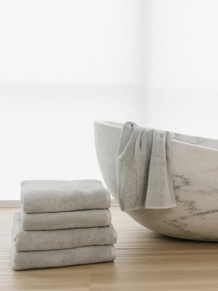 Complete Ribbed Terry Bath Bundle in the color Light Grey. Photo of Complete Ribbed Terry Bath Bundle taken in a bathroom next to a bathtub. |Color: Light Grey