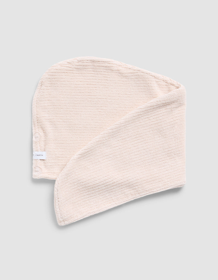 A folded Ribbed Terry Hair towel in Petal on a grey background |Color:Petal