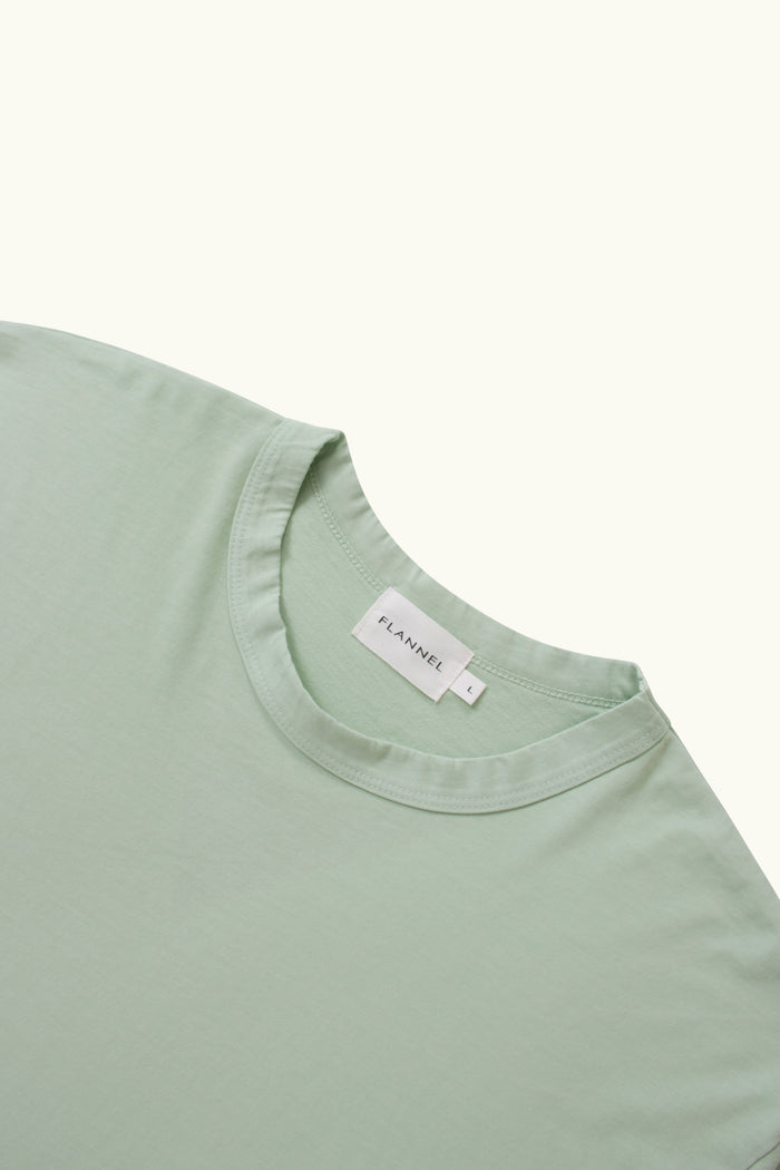 Close up of light green cotton t-shirt white background