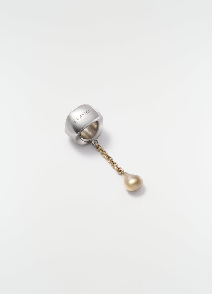 Scarf ornament in brass with chain and pearl detail by LEMAIRE on white background close-up.