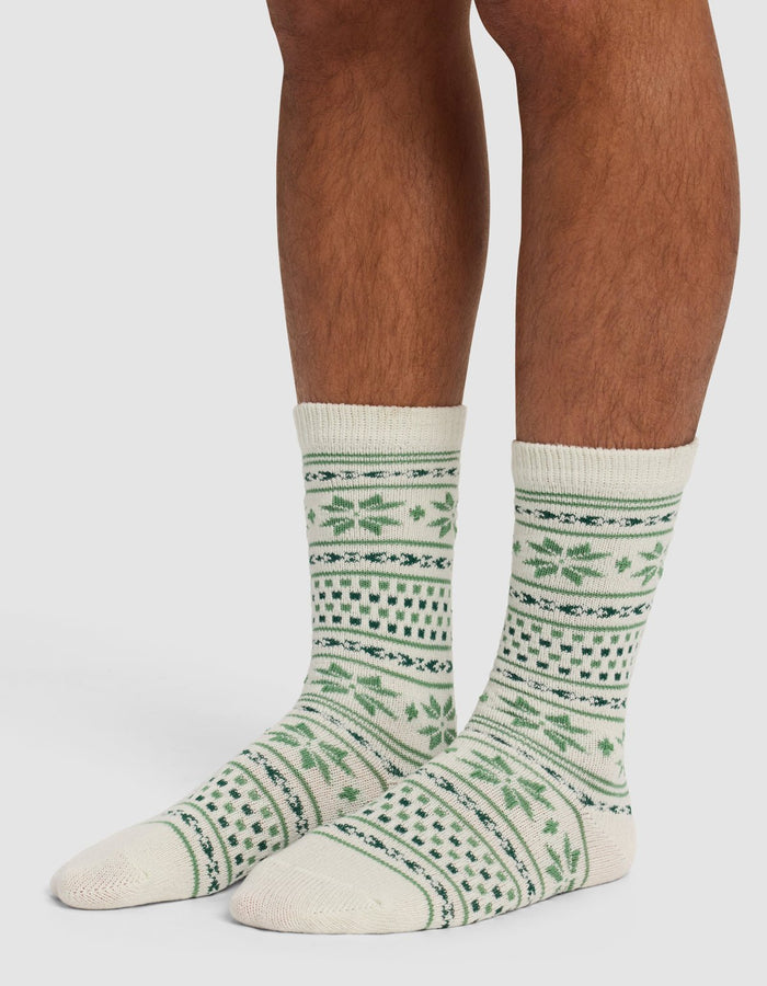 A person wearing The Snowflake Plush Lounge Sock by Cozy Earth.|Color:Celadon