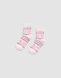 The Snowflake Plush Modern Crew Sock by Cozy Earth is a light pink pair featuring darker pink and black geometric patterns, including stripes and star shapes, displayed flat on a plain gray background.|Color:Ballet
