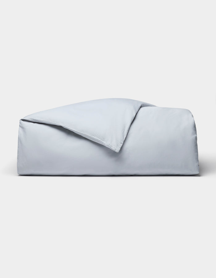 The Cozy Earth Soft-Wash Cotton Duvet Cover set, in light blue, is neatly folded and displayed against a plain white background.|Color:Shore