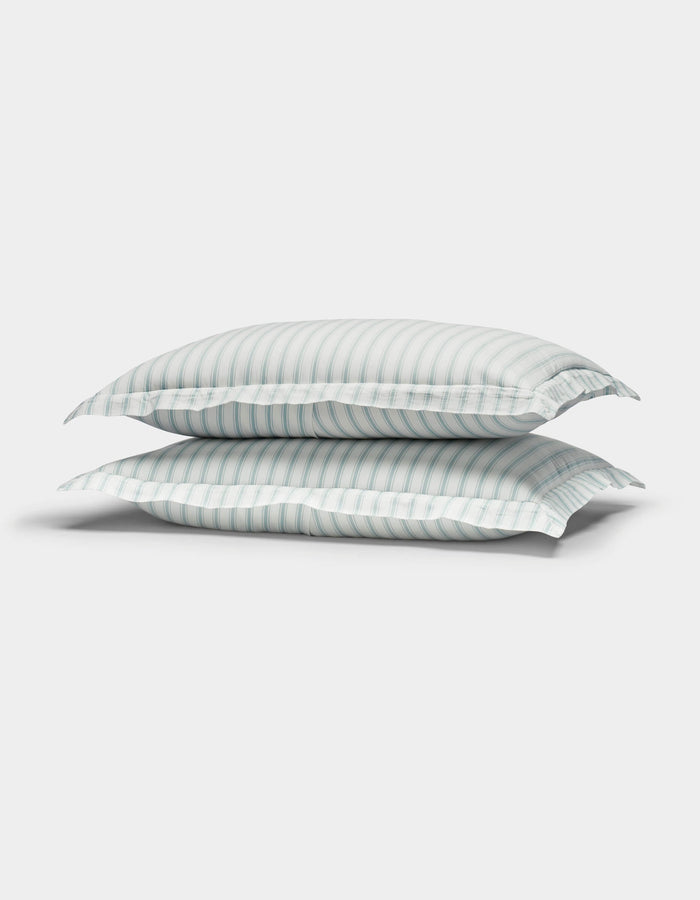 Two Cozy Earth Soft-Wash Cotton Quilted Shams in white with light blue and gray stripes are stacked together against a plain white background.|Color:River and Sea Salt Stripe