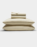 The Cozy Earth Soft-Wash Cotton Sheet Set in beige and light brown stripes is neatly stacked with two pillows at the base, topped with folded sheets and a pillowcase, displayed against a plain white background.|Color:Coconut and Sandalwood Stripe