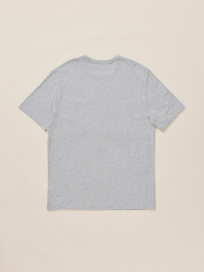 A light gray heather short-sleeve t-shirt shown from the back, laid flat against a solid beige background.