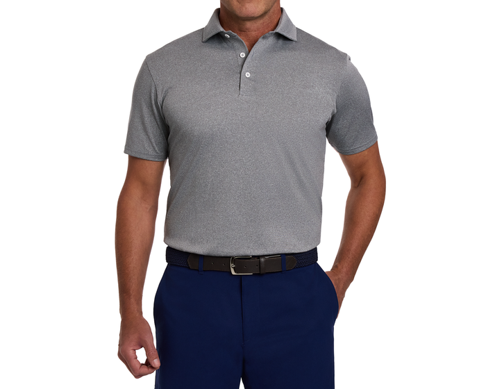 Man wearing The Anderson Shirt: Heathered Gray, a light-grey polo with short sleeves, tucked into navy trousers with a woven navy belt.