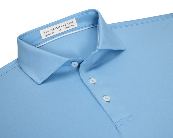 The Anderson Shirt: Vista Blue, featuring a structured spread collar, three-button placket, and Holderness & Bourne label, offers stretch and moisture-wicking performance fabric.