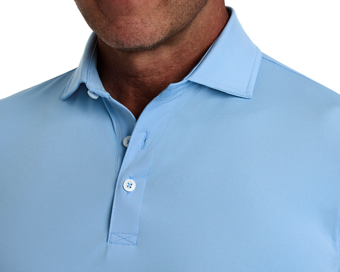The Anderson Shirt: Vista Blue, featuring a structured spread collar and two-button placket, offers stretch and moisture-wicking for comfort on and off the course.