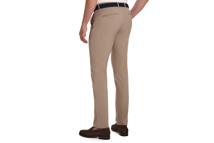 The Anson Chino Pant: Fescue, featuring slim-fit design with slant pockets, a dark woven belt, and brown suede loafers for polished on-course style.