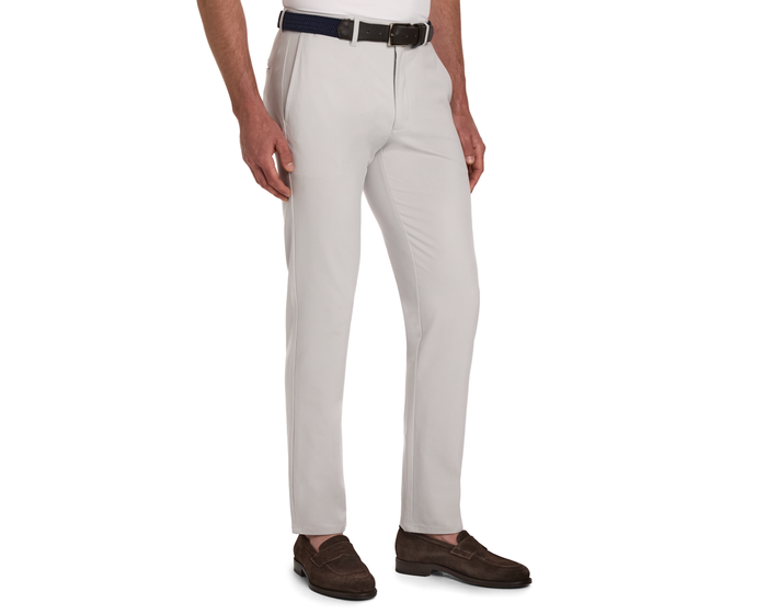 The Anson Chino Pant: Stone, featuring classic slant pockets, shown with a black belt and dark brown suede loafers, highlighting its polished, wrinkle-resistant fabric.