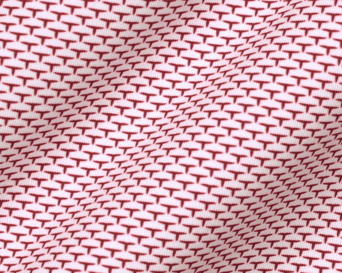 The Armfield Shirt: Liberty Red features a close-up of its red “T”-shaped motif on light fabric, highlighting the refined geometric pattern and texture.