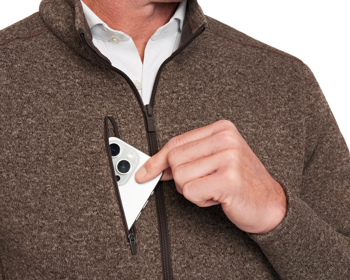 Person wearing a Holderness & Bourne Men’s Chestnut Fleece Jacket with a white shirt, holding a smartphone with a white case.