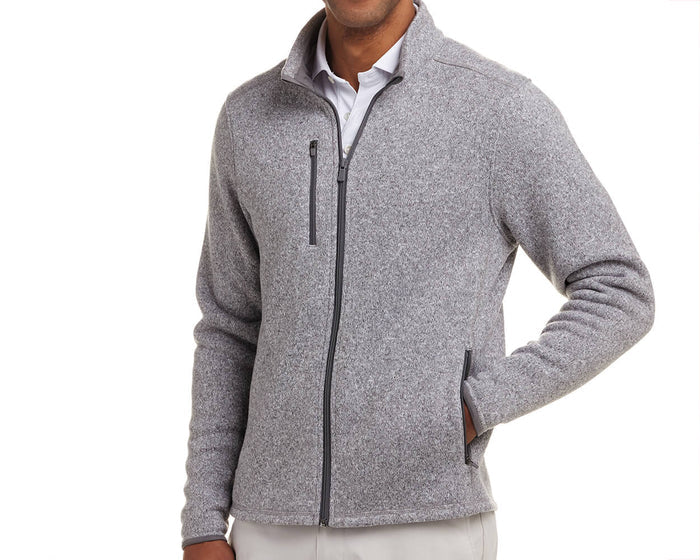 The Ashby Jacket: Heathered Gray, a light-grey, full-zip fleece with stretch, stand-up collar, chest pocket, and zippered hand pockets, worn over a white shirt.