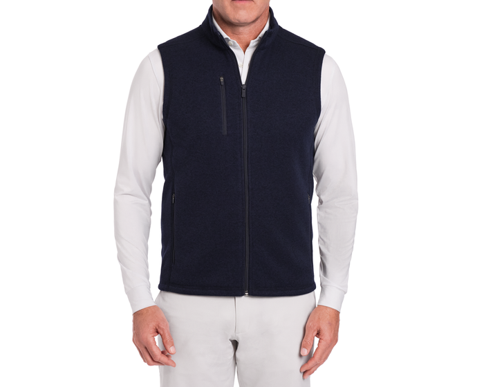 The Ashby Vest: Heathered Dark Navy, shown on a model over a white shirt, features zippered pockets and a soft brushed interior for versatile comfort.