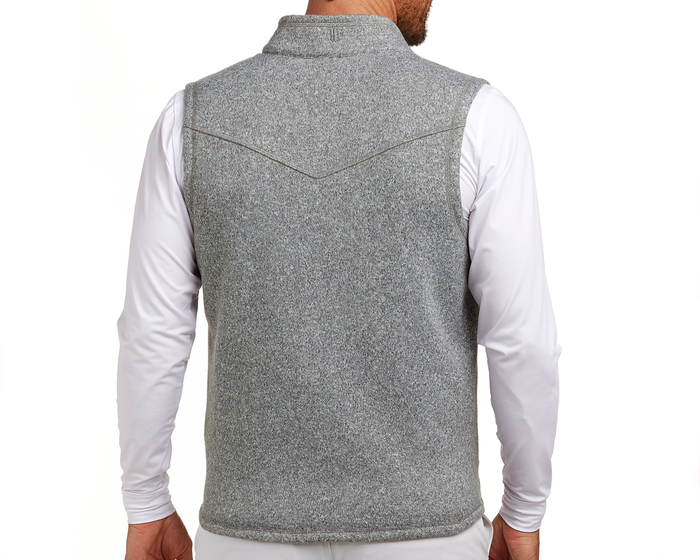 The Ashby Vest: Heathered Gray, shown from the back, features a sleeveless design over a white shirt, with tonal accents and a brushed interior for comfort.