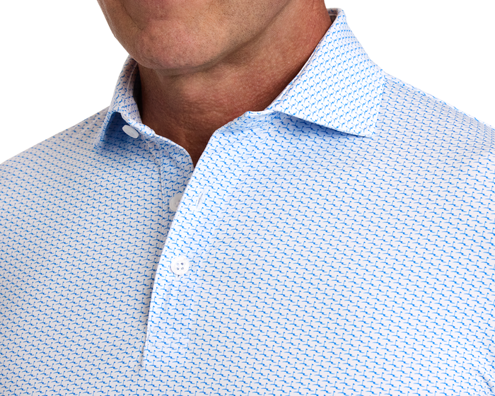 The Atwood Shirt: Horizon Blue, featuring a light blue with dark blue geometric pattern, open collar, structured spread collar, and part of a man's tanned jawline.