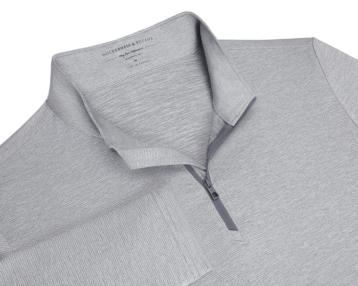 The Bell Quarter-Zip: Heathered Gray, featuring a textured knit, fold-over collar, quarter-zip placket, and long sleeves, offering sporty sophistication and versatility.