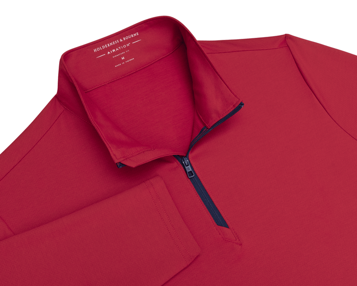 The Bell Quarter-Zip: Heathered Liberty Red features a long-sleeve design, dark zipper placket, stand-up collar with visible branding, offering sporty sophistication.