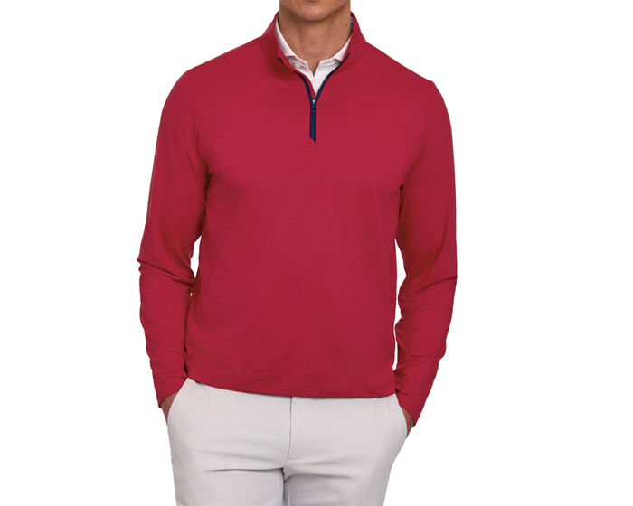Person wearing The Bell Quarter-Zip: Heathered Liberty Red over a white shirt, paired with light-beige trousers, hands in pockets, showcasing a sporty, sophisticated style.
