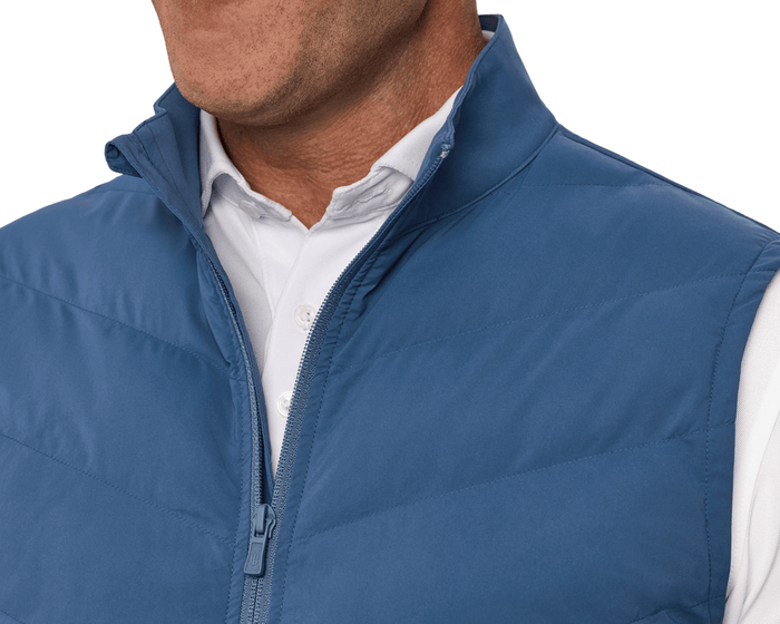 Person wearing The Benton Vest: Andover, featuring a quilted, zip-up front with Thermore® insulation and a knit back for enhanced mobility and comfort.