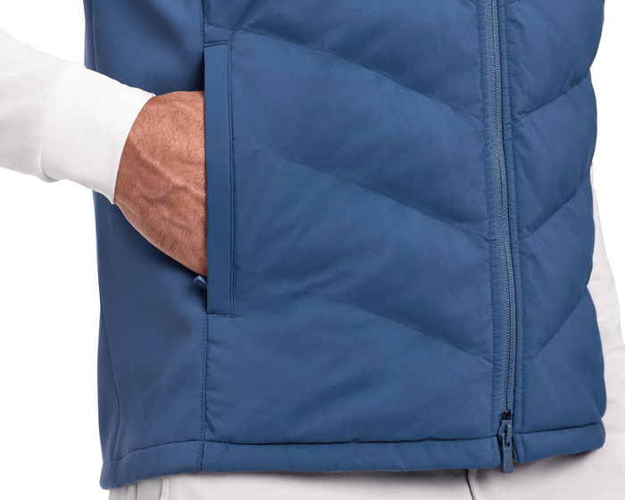 Close-up of The Benton Vest: Andover, showcasing a quilted front with a visible zipper and side pocket, worn over a long-sleeve shirt.