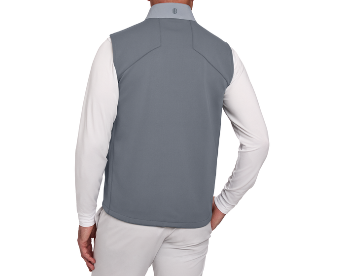 Person wearing The Benton Vest: Gray, showcasing its sleeveless design and seamless shoulder lines, paired with a white shirt, highlighting its comfort and mobility features.