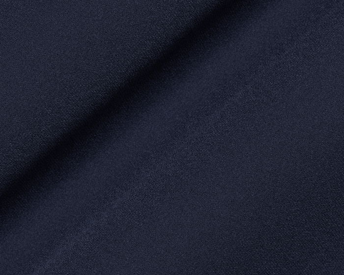 Close-up of The Benton Vest: Navy, showcasing its fine woven texture with a slight cloth fold, highlighting the knit back stretch construction for mobility.