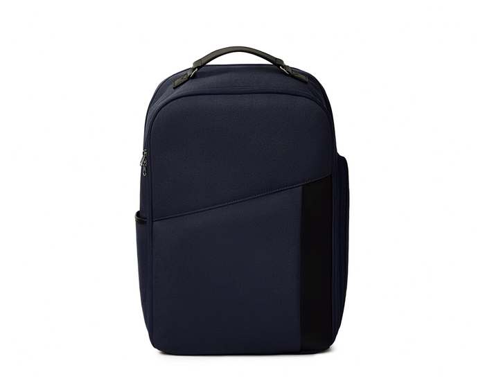 The Broughton Backpack: Navy Ballistic - Navy Embroidery, features a sleek design with a main compartment, slanted front pocket, and side pocket, ideal for travel.