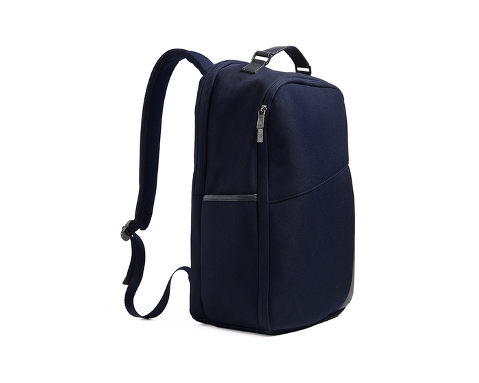 The Broughton Backpack: Navy, showcasing a sleek side view with padded shoulder straps, top handle, and zippered compartments for laptop and accessories.