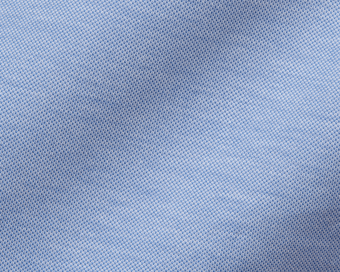 The Cullinane Shirt: Heathered Maidstone Blue features a close-up of its light-blue piqué texture, showcasing breathable knit and stylish, polished comfort.