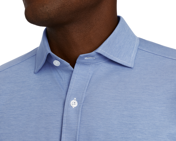 The Cullinane Shirt: Heathered Maidstone Blue features a pointed collar, white buttons, and textured fabric, showcasing breathable, stretchable cotton-blend with UPF 30+ protection.