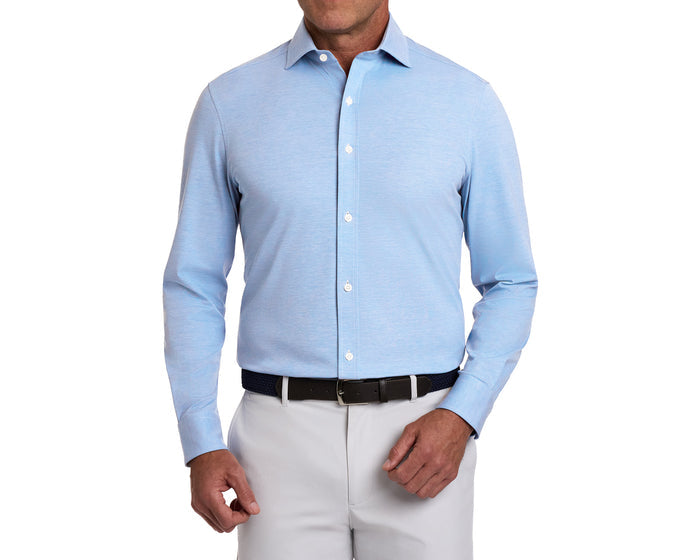 The Cullinane Shirt: Heathered Vista Blue, a light-blue, long-sleeve, button-front shirt, worn tucked into light gray trousers with a dark belt.