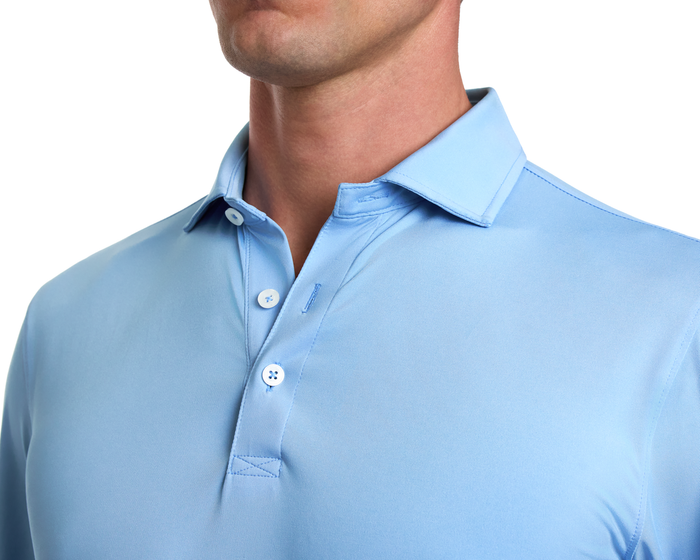 The Farrell Shirt: Vista Blue features a light-blue, short-sleeve polo with a spread collar and three-button placket, showcasing smooth knit fabric.