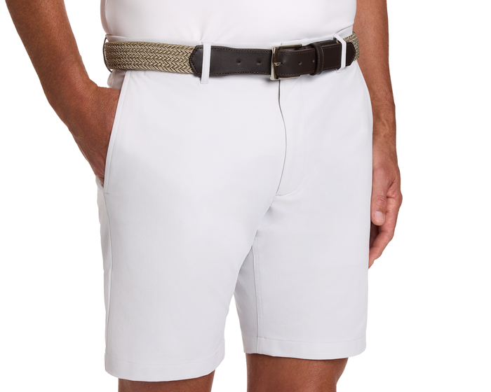 Person wearing light-colored shorts and The Fischer Belt: Dune & Fescue Microstripe, featuring a braided design with leather ends and a metal buckle.