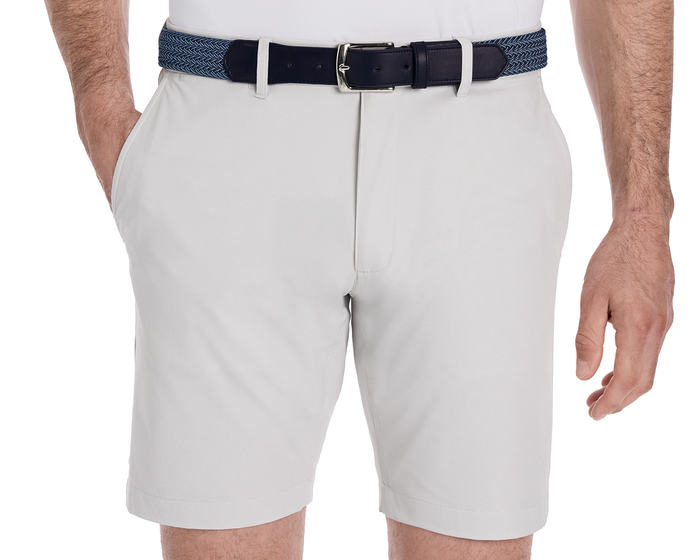 A man wears light-gray shorts with The Fischer Belt: Navy & Slate Microstripe, featuring a navy woven design and a silver buckle, tucked into side pocket.