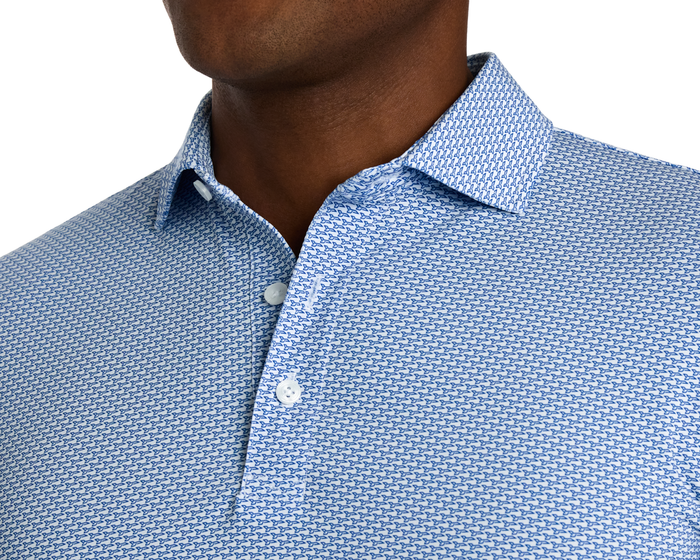 The Hanover Shirt: Maidstone Blue features a light-blue polo with a geometric motif, pearly buttons, four-way stretch, and UPF 50+ protection.