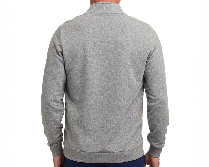 Back view of The Harper Quarter-Zip: Heathered Gray, showcasing its logo below the collar, ribbed cuffs, and hem, worn with dark pants.